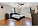 Bedroom with hardwood floors, two windows, a ceiling fan and a comfortable bed and matching furniture at 1852 W 62Nd St, Indianapolis, IN 46260
