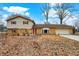 Split-level home features a two car garage, solar panels, and mature trees at 1852 W 62Nd St, Indianapolis, IN 46260