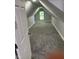 This attic room has neutral carpeting, paint and a bright window at 2312 Fletcher St, Anderson, IN 46016
