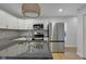 Open kitchen featuring stainless steel appliances, granite countertops, tile backsplash, and hardwood flooring at 2312 Fletcher St, Anderson, IN 46016