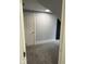 A simple, finished room with carpeting, neutral walls, and a modern door at 2312 Fletcher St, Anderson, IN 46016
