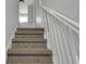 Carpeted staircase with a white handrail and natural light at 2312 Fletcher St, Anderson, IN 46016