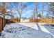 A spacious backyard enclosed by a privacy fence, offering a peaceful outdoor retreat covered in snow at 26 Highland Ave, Franklin, IN 46131