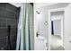Updated bathroom with black tiled shower, modern vanity, and a view to another room at 26 Highland Ave, Franklin, IN 46131