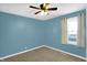 Cozy bedroom featuring plush carpet, blue walls, a ceiling fan, and a bright window with curtains at 26 Highland Ave, Franklin, IN 46131