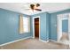 Light-filled bedroom with soft carpet, blue walls, closet, window, and fan at 26 Highland Ave, Franklin, IN 46131