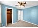 Comfortable bedroom with neutral carpet, blue walls, closet, ceiling fan, and a bright window at 26 Highland Ave, Franklin, IN 46131