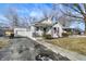 A cozy bungalow-style home with white siding, front porch, driveway, and a detached garage at 26 Highland Ave, Franklin, IN 46131