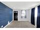 A cozy living room with a blue accent wall, plush carpeting, and ample natural light at 26 Highland Ave, Franklin, IN 46131