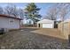 Spacious backyard featuring a detached garage, mature trees, and a fully fenced perimeter at 2610 Caroline Ave, Indianapolis, IN 46218
