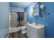 Classic blue bathroom with a floral shower curtain and a charming vanity at 2610 Caroline Ave, Indianapolis, IN 46218