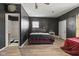 Bedroom featuring dark walls, wood-look flooring, and a walk-in shower, offering a unique and modern living space at 2610 Caroline Ave, Indianapolis, IN 46218