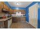 Well-lit kitchen featuring wood cabinets, laminate flooring, and essential appliances for a functional cooking space at 2610 Caroline Ave, Indianapolis, IN 46218