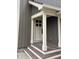 Covered front porch and modern front door with white trim and grey vertical siding at 307 S Main St, Whitestown, IN 46075