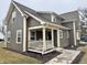 Craftsman-style home featuring vertical siding, a covered porch, and manicured landscaping at 307 S Main St, Whitestown, IN 46075