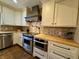 Close-up of a kitchen showcasing stainless steel appliances, custom cabinetry, and tile backsplash at 307 S Main St, Whitestown, IN 46075