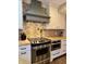 Stainless steel oven and range hood paired with custom white cabinets in kitchen at 307 S Main St, Whitestown, IN 46075