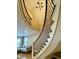 Elegant curving staircase with dark wrought iron balusters and views of the living area at 307 S Main St, Whitestown, IN 46075
