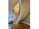 Elegant curved staircase with wooden handrail and modern chandelier, enhancing the home's charm at 307 S Main St, Whitestown, IN 46075