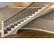 Well-lit staircase showcasing wooden steps and an elegant railing, complementing the home's neutral color scheme at 307 S Main St, Whitestown, IN 46075