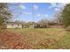 Large backyard with mature trees, patio, playset, and wood fence at 3645 Glencairn Ln, Indianapolis, IN 46205