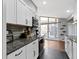 Modern kitchen with white cabinets, granite countertops, and direct access to backyard at 3645 Glencairn Ln, Indianapolis, IN 46205