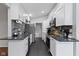 Galley kitchen featuring white cabinets, granite counters, stainless steel appliances, and modern backsplash at 3645 Glencairn Ln, Indianapolis, IN 46205