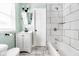 Modern bathroom with white tile, updated fixtures, and painted in a calming light green at 3708 Rockville Rd, Indianapolis, IN 46222