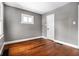 Bright bedroom with hardwood floors, natural light, and painted in a modern grey at 3708 Rockville Rd, Indianapolis, IN 46222