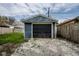 Detached one-car garage with a black overhead door and gray gravel beyond it at 3708 Rockville Rd, Indianapolis, IN 46222