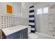Bright bathroom with a combined tub and shower, dark blue vanity, and patterned backsplash at 4018 S State Road 75, Coatesville, IN 46121
