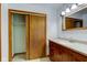 Bathroom with marble counter, modern sink, mirror with lights, sliding wooden door and light tile at 4018 S State Road 75, Coatesville, IN 46121