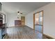 Open living room with hardwood floors, ceiling fan, and brick accent wall at 4018 S State Road 75, Coatesville, IN 46121