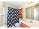 Cozy bathroom includes a shower with floral curtain, toilet, vanity with a mirror at 5142 Pin Oak Dr, Indianapolis, IN 46254