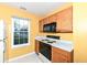 Functional kitchen with ample wood cabinetry, white countertops, and a sunny window over the sink at 5142 Pin Oak Dr, Indianapolis, IN 46254
