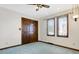 Bedroom featuring a closet with panel doors, and two windows with blinds, and light blue carpet flooring at 5272 N Graham Rd, Whiteland, IN 46184