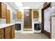 Practical laundry room with wooden cabinets, front load washer and dryer, and unique wallpaper design at 5272 N Graham Rd, Whiteland, IN 46184