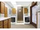 Well-lit laundry room with cabinetry and countertop area, featuring two modern, front-loading washing machines at 5272 N Graham Rd, Whiteland, IN 46184