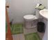 Functional bathroom with a toilet, sink, and green accent rugs at 5506 N Drexel Ave, Indianapolis, IN 46220