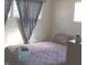 Simple bedroom with a patterned bedspread, cozy pillows, and a window with dark curtains for privacy at 5506 N Drexel Ave, Indianapolis, IN 46220