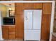 Functional kitchen with wooden cabinets, stainless steel fridge, and built-in microwave at 5506 N Drexel Ave, Indianapolis, IN 46220
