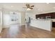 Open floor plan showcasing hardwood floors, a ceiling fan, and a view of the kitchen and dining area at 660 Overcup St, Westfield, IN 46074