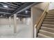 Finished basement with gray painted ceiling joists and white floors at 7999 Englewood Rd, Indianapolis, IN 46240