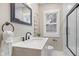 Bathroom with a framed mirror above the sink, window for natural light, and a sleek glass-enclosed shower at 7999 Englewood Rd, Indianapolis, IN 46240