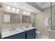 Modern bathroom featuring double sinks, sleek fixtures, and a glass-enclosed shower at 7999 Englewood Rd, Indianapolis, IN 46240