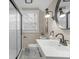 Bathroom featuring a glass-door shower, modern light fixtures, and a stylish round mirror at 7999 Englewood Rd, Indianapolis, IN 46240