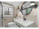Bathroom featuring a glass-door shower, modern light fixtures, and a stylish round mirror at 7999 Englewood Rd, Indianapolis, IN 46240