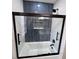 Sleek bathroom with contrasting tile, matte black shower fixtures, and a glass door at 7999 Englewood Rd, Indianapolis, IN 46240