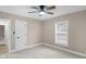 Inviting bedroom featuring a ceiling fan, large window, neutral walls, and plush carpeting at 7999 Englewood Rd, Indianapolis, IN 46240