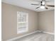 Sunlit bedroom with a modern ceiling fan, window with blinds, and plush carpeting at 7999 Englewood Rd, Indianapolis, IN 46240